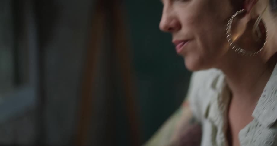 Woman with arm tattoo types on laptop