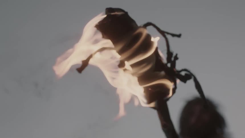 A man lifting a burning torch