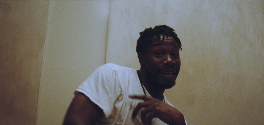 Young happy man wearing a white shirt dances alone energetically on a room