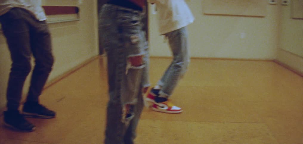 Group of happy people performing a choreographed dance in front of a mirror on a studio