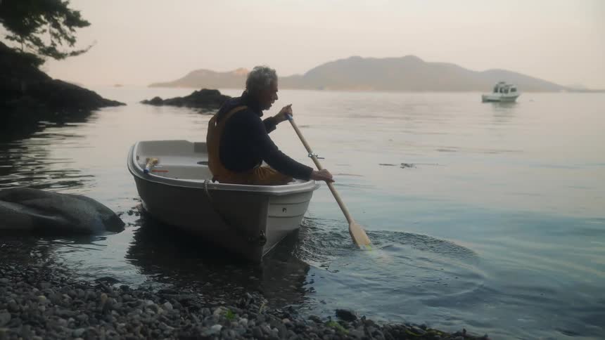 A man pushes his boat away from the shore