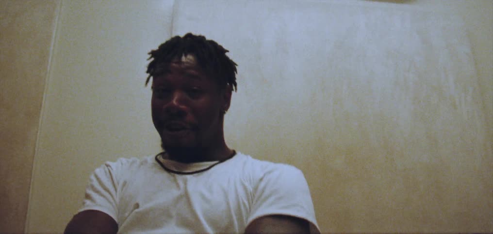 Young happy man wearing a white shirt dances alone energetically on a room