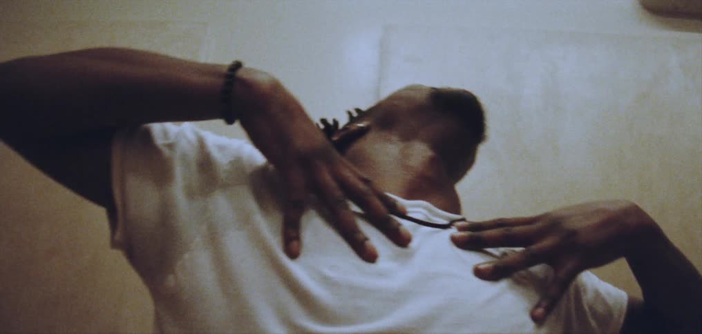 Young happy man wearing a white shirt dances alone energetically on a room