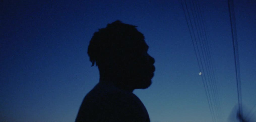 Man dances outdoors silhouetted against night sky