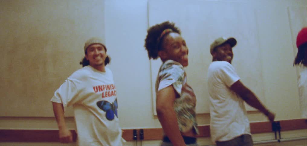A group of dancers perform a synchronized dance indoors