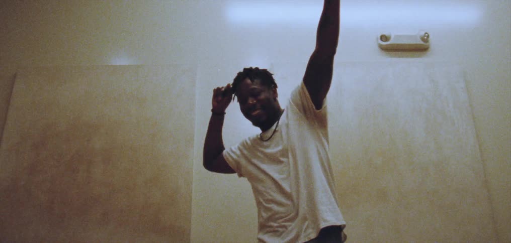 A man snaps his fingers while dancing indoors