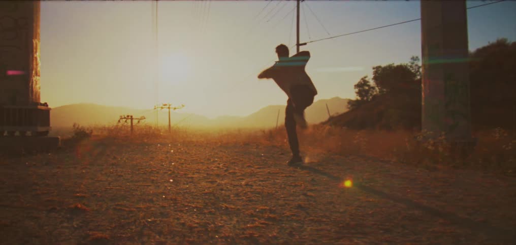 A man performs a hip hop style dance in a field