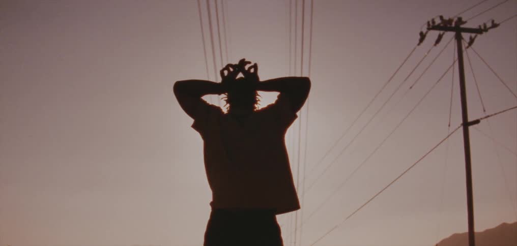 Silhouette of a young man dancing on the countryside at evening