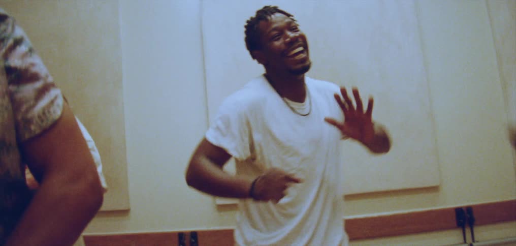 A group of men and women do a synchronized dance indoors