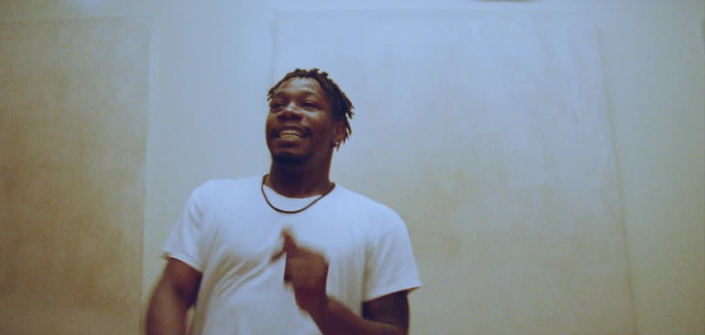 A man smiles as he dances indoors with others