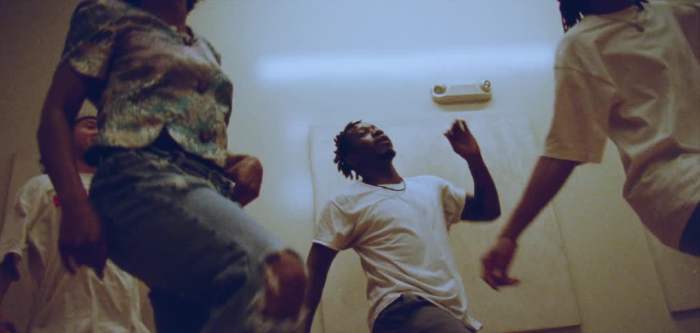 Four person dance troop dances together in white walled room