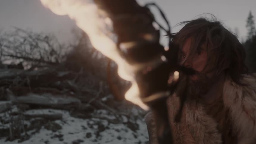 A man holds a torch in the snow