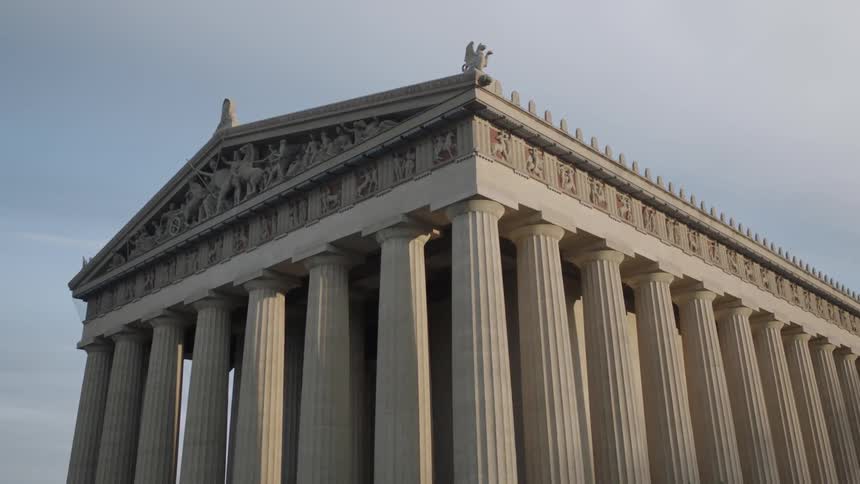 The parthenon stands out against a partially cloudy sky