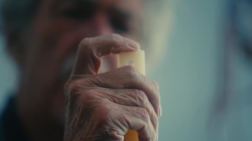 A man holds up a long tube to examine