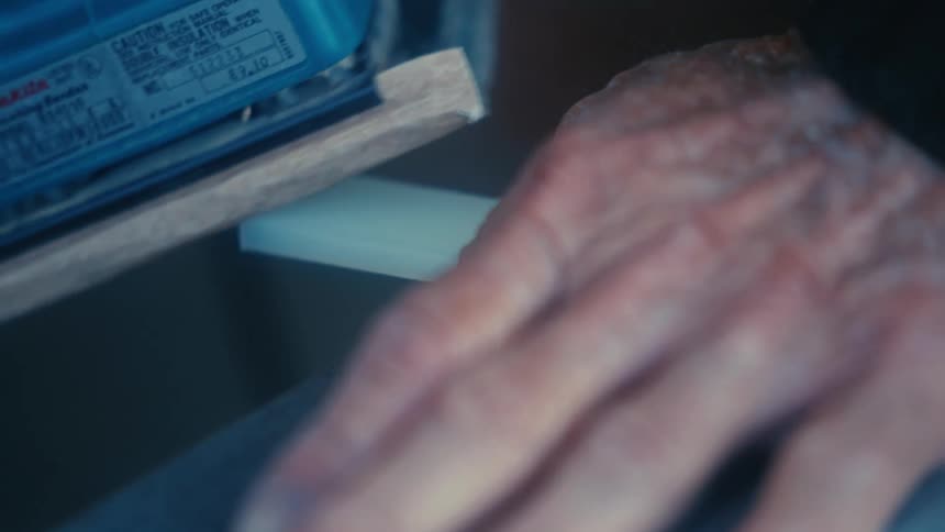 A person sanding a piece of plastic