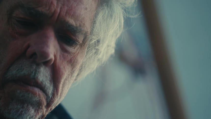 Close up of the face of an elderly man concentrated on a task outdoors