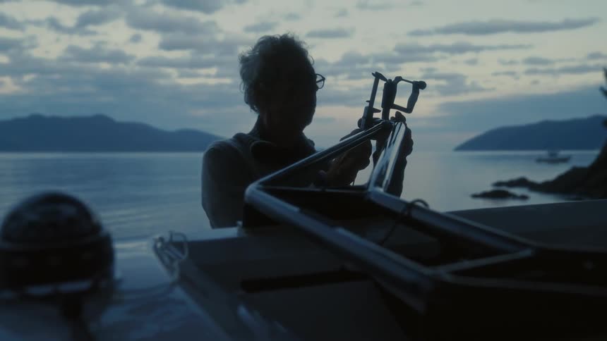 The man is attaching something to the boat