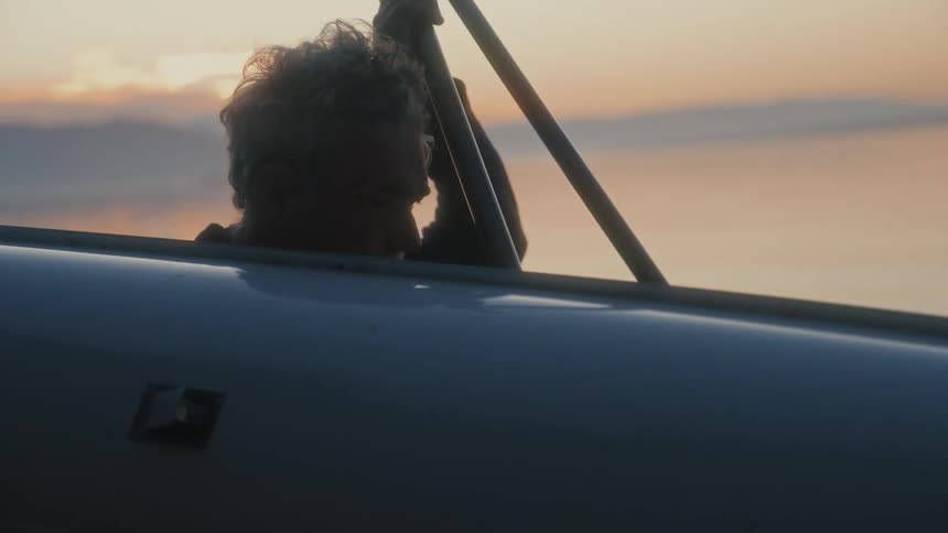 The man is carrying is kayak by the water