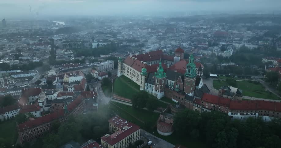 Aerial view of a castle or fort built atop a hill on an european city at evening