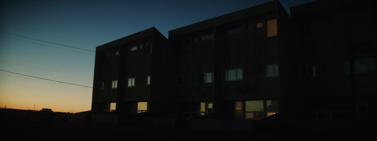 Silhouette of the facade of a pair of low residential buildings at evening