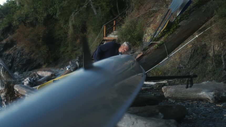A man is checking his canoe on the shore