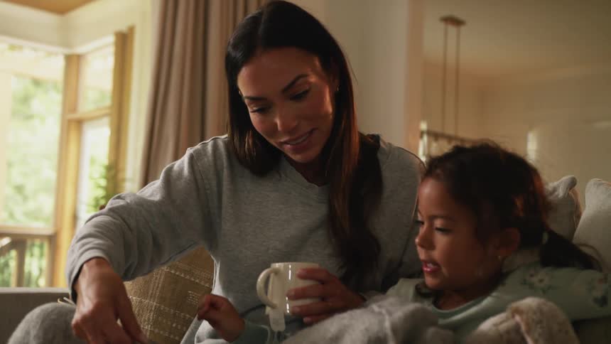 A mother looks at a book with her daughter