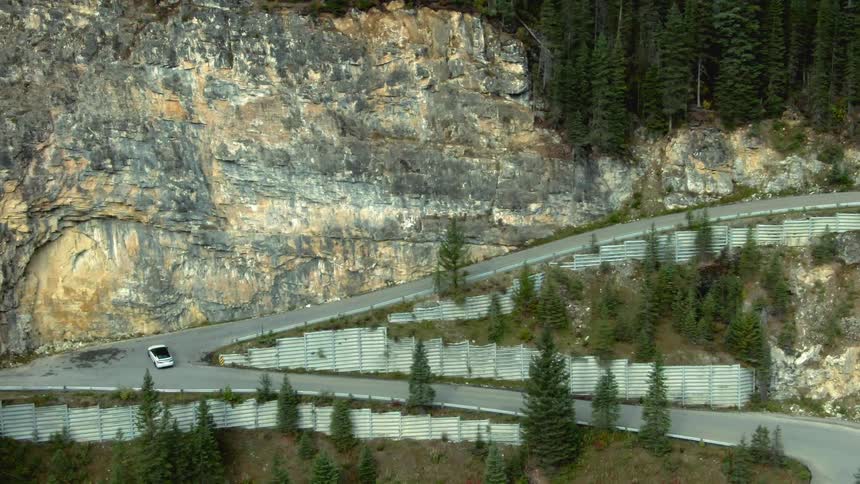 An aerial view of a car driving down a road