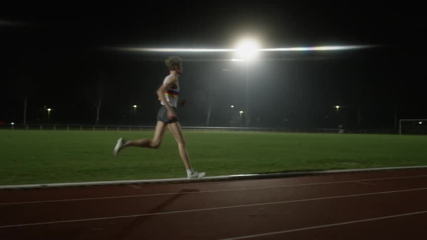 A man running on a track at night
