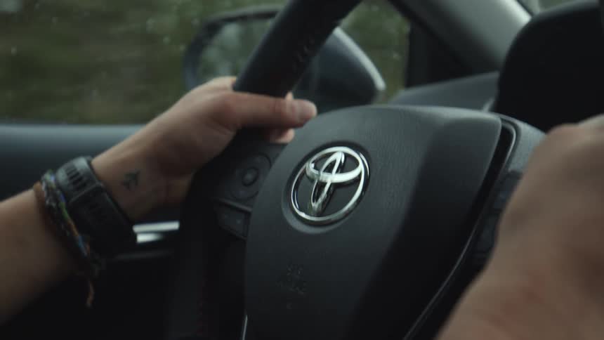 A person is driving a car during the spring