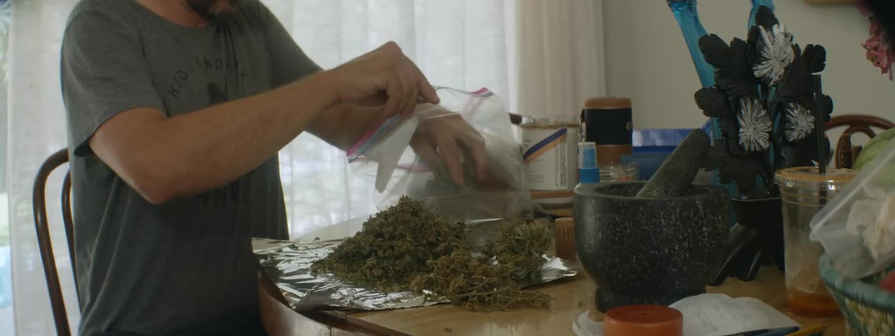 A man working with weed in a house