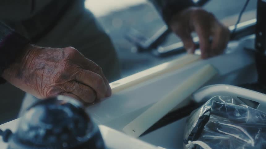 A man is building an object outdoors during midday