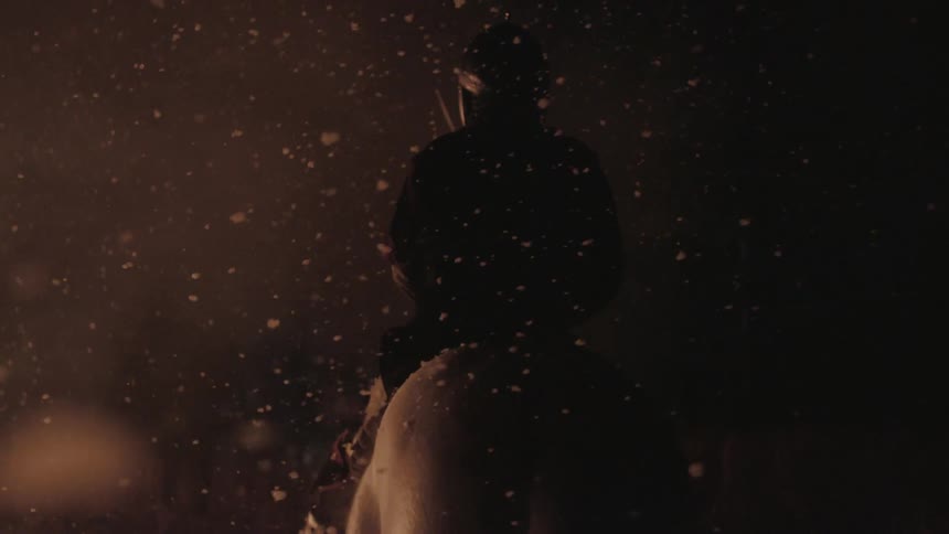A man sits on a horse at night