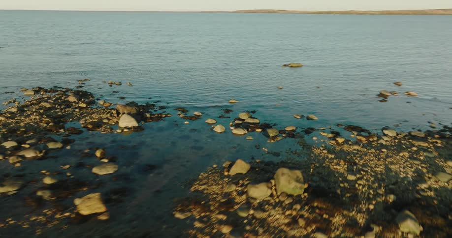 The shore is lined with stones