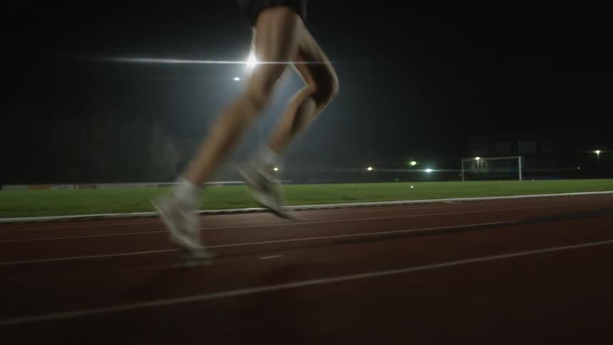 A person running on a track at night
