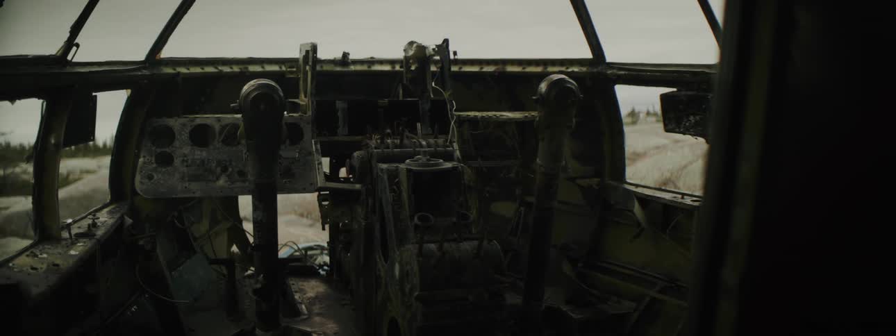 Cockpit on the dismantled interior of an abandoned airplane fuselage in the countryside