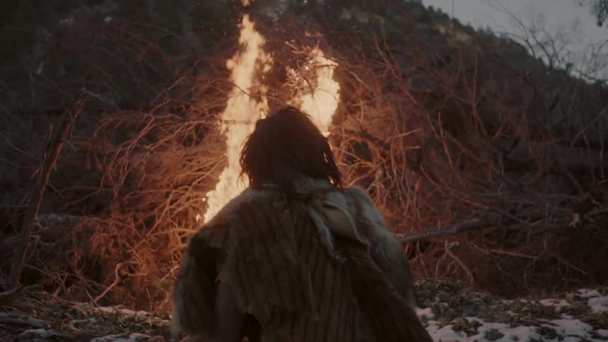 Wilderness man standing in front of a brush fire