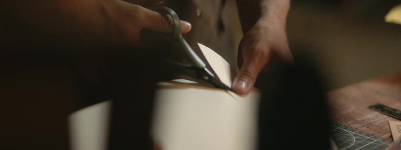 A worker is cutting a piece of material