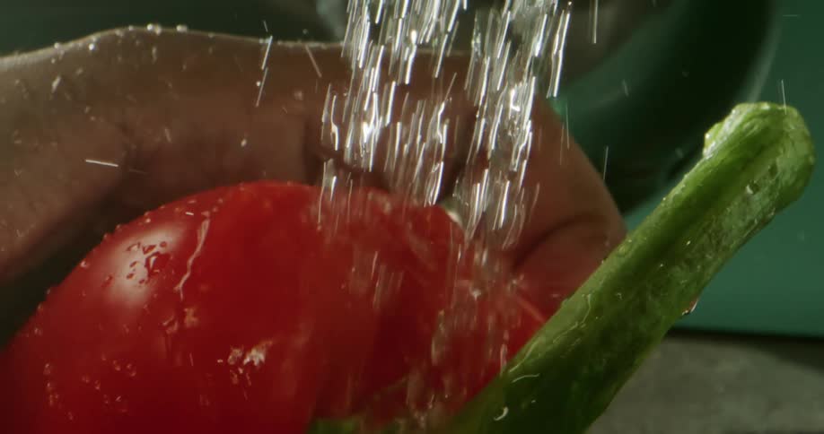 A person is washing a pepper