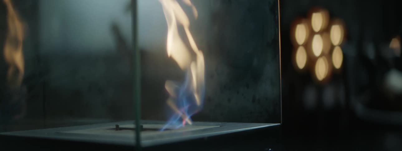 Live flame burns within glass enclosure in building