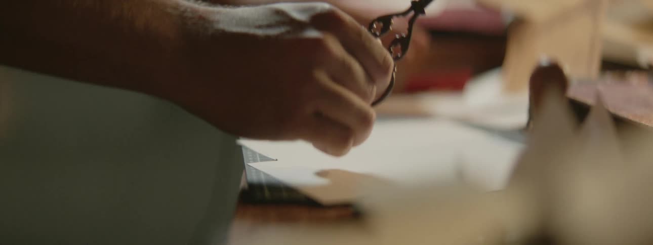 Crafter uses scissors to work on paper craft