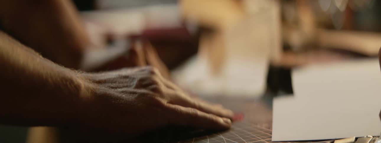 A person is folding a piece of paper on a table