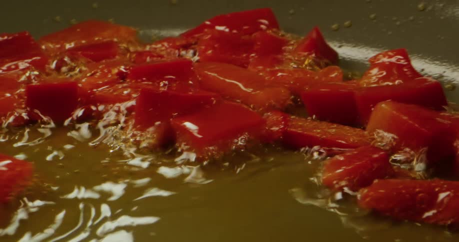 Tomato chucks are fried in oil on a pan