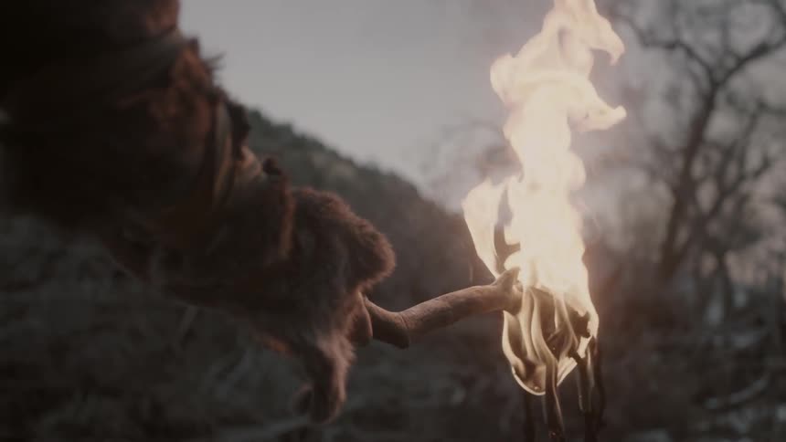 A man holds a torch on a cloudy day