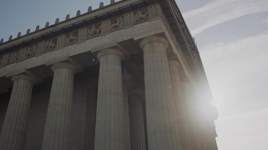 View of an ancient structure with the sun shining brightly behind it