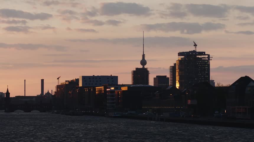 Tv tower in the berlin skyline seen from the spree river at evening