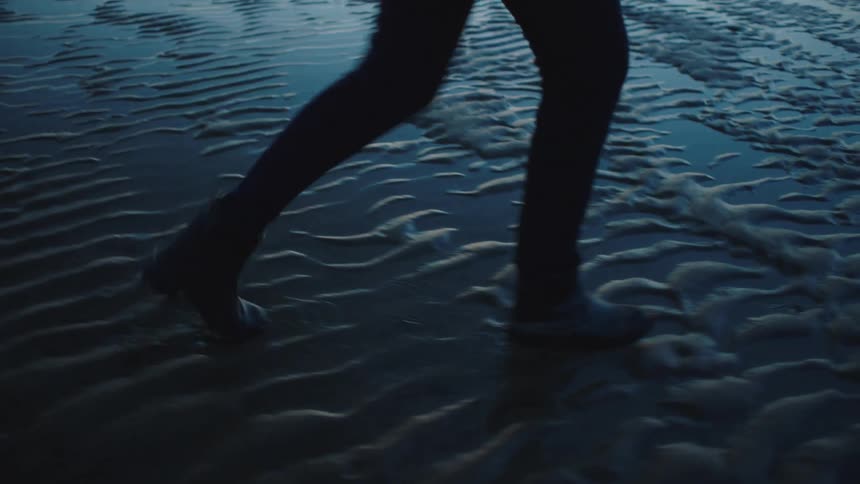 Person walks across wet sand