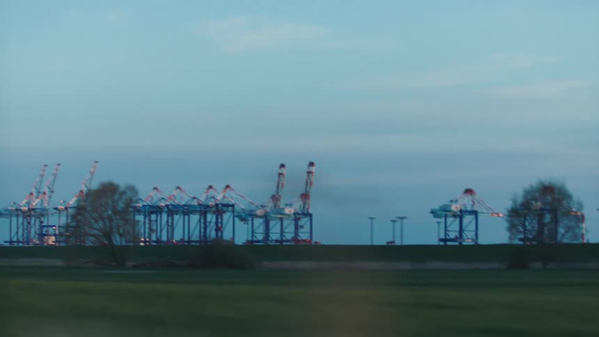 Loading cranes sits on edge of field under a cloudy sky