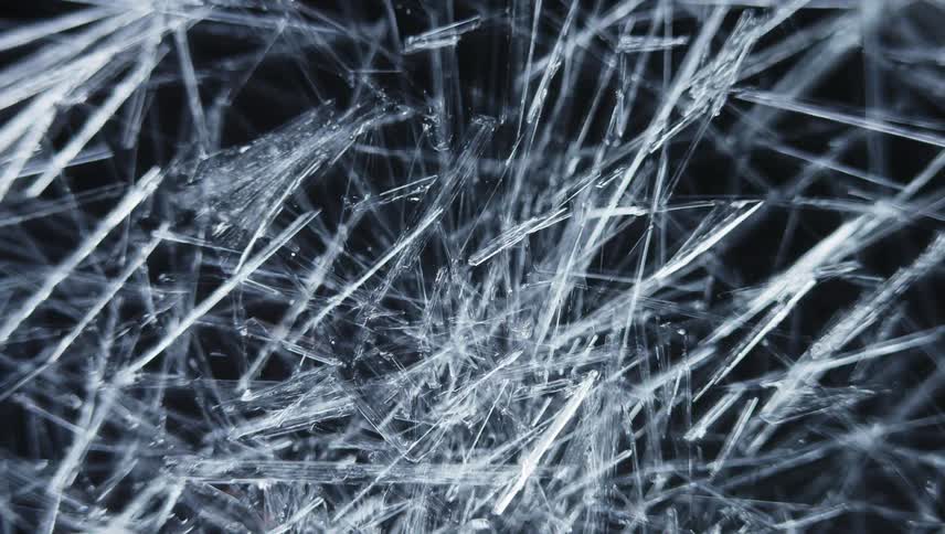 Icy crystalline shards spread and cover black surface