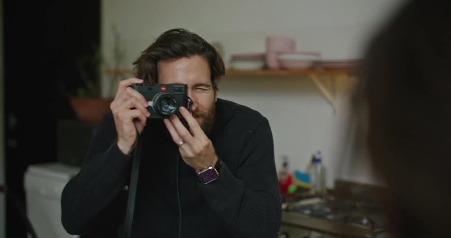 A man takes a photograph at home