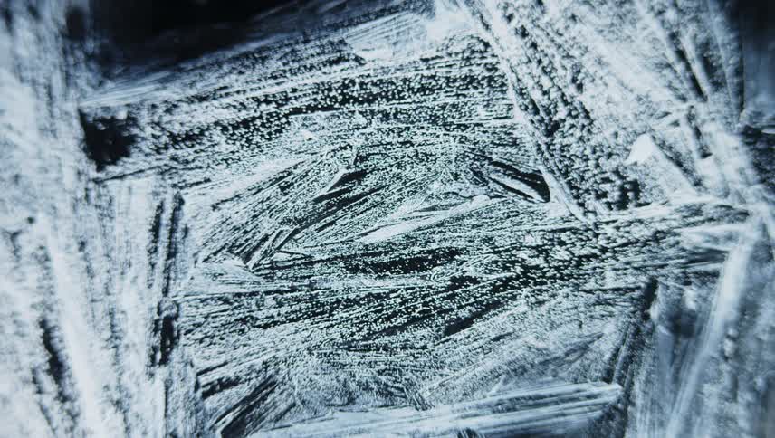 Ice frost forms on dark glass
